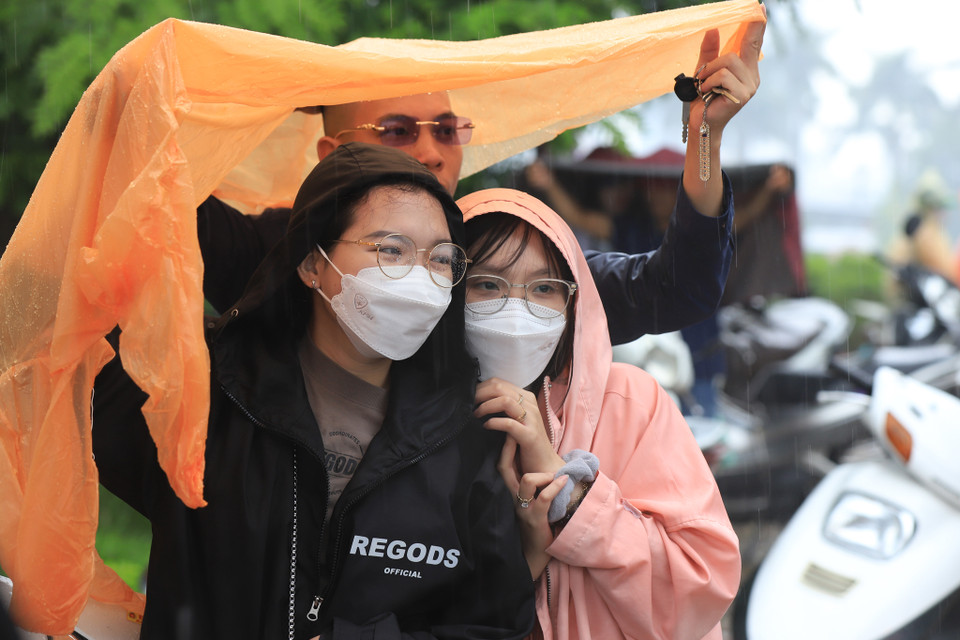 Một số khán giả dõi theo sự kịch tính của cuộc đua dưới cơn mưa rào buổi sáng nay. (Ảnh: Hoài Nam/Vietnam+)