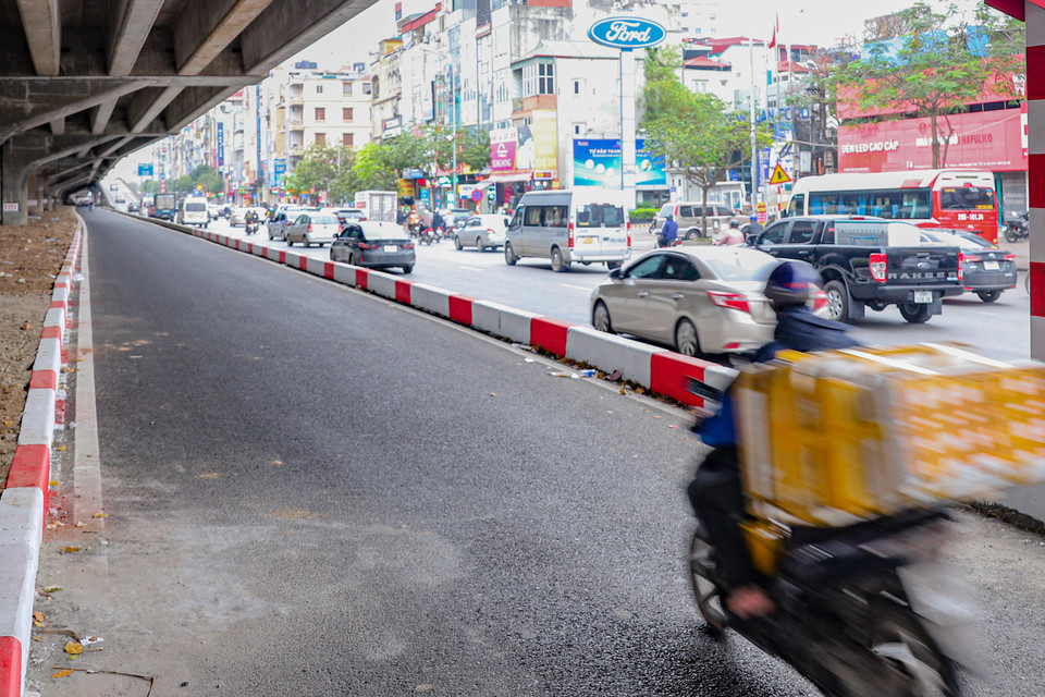 Theo ghi nhận của phóng viên Báo Điện tử VietnamPlus, trong khi phía bên ngoài phần đường cũ luôn đông đúc thì phía làn mở rộng lại trống không, 2 đầu đường bị chặn lại bằng các khối bê tông chưa cho người dân sử dụng. (Ảnh: Hoài Nam/Vietnam+)