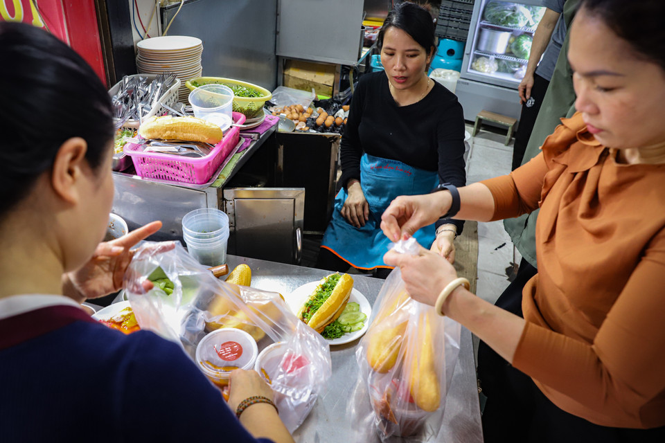 Chẳng cần hàng quán, chẳng cần chỗ ngồi hay nơi để xe, chỉ cần tấp vào lề, gạt chân chống, gọi to loại bánh mình muốn mua là 5 phút sau đã có chiếc bánh nóng hổi ngon lành mang đến lớp học, công ty,... (Ảnh: Hoài Nam/Vietnam+)