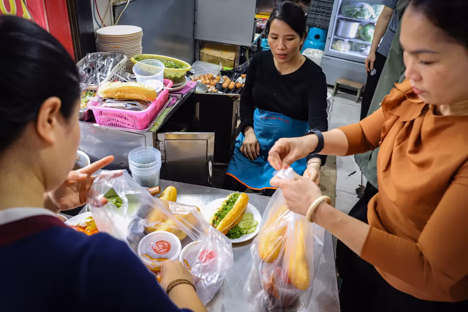 Chẳng cần hàng quán, chẳng cần chỗ ngồi hay nơi để xe, chỉ cần tấp vào lề, gạt chân chống, gọi to loại bánh mình muốn mua là 5 phút sau đã có chiếc bánh nóng hổi ngon lành mang đến lớp học, công ty,... (Ảnh: Hoài Nam/Vietnam+)