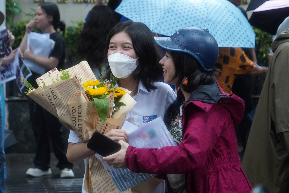 Phụ huynh chờ đón con với bó hoa tươi thắm. (Ảnh: PV/Vietnam+)