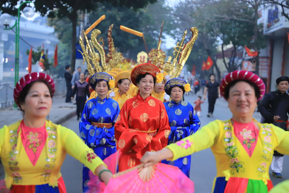 Sau hồi chiêng trống, cuộc rước chính thức bắt đầu, các chân kiệu bắt đầu rước long kiệu từ trong đình ra. Đi đầu là năm lá cờ ngũ hành; đội múa cờ; đội trống; đội múa sư tử; ngựa hồng, ngựa bạch; đội múa bồng; hương án; đoàn phật tử; đội bát bửu... (Ảnh: Hoài Nam/Vietnam+)
