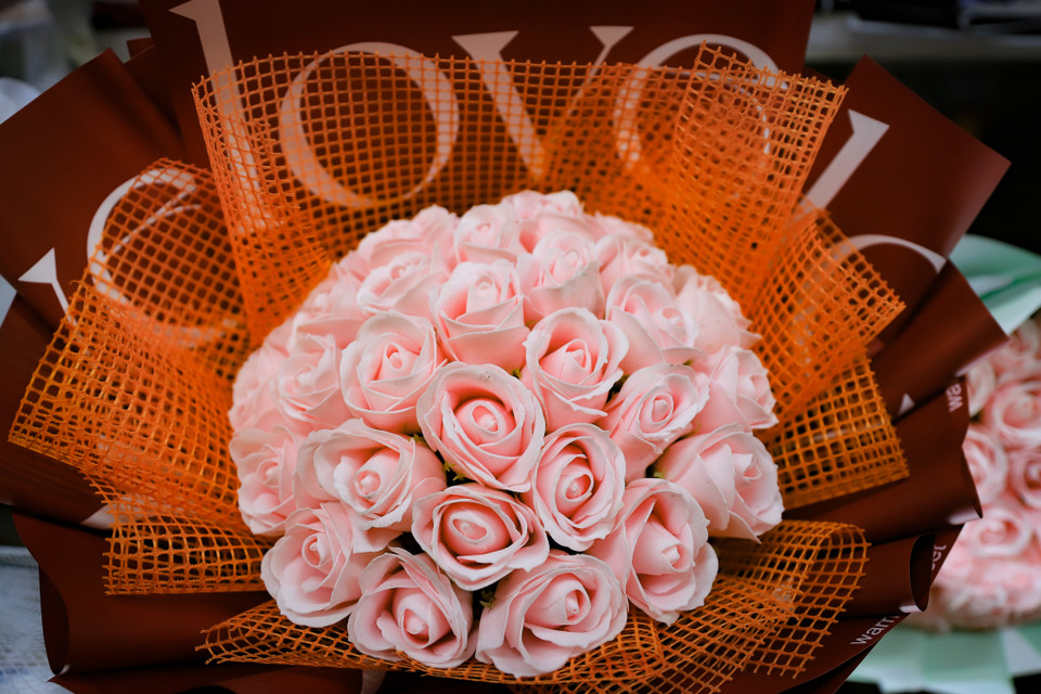 Bên cạnh hoa tươi, một số cửa hàng còn có những mẫu hoa giả bằng giấy để cho khách hàng lựa chọn. (Ảnh: Hoài Nam/Vietnam+)