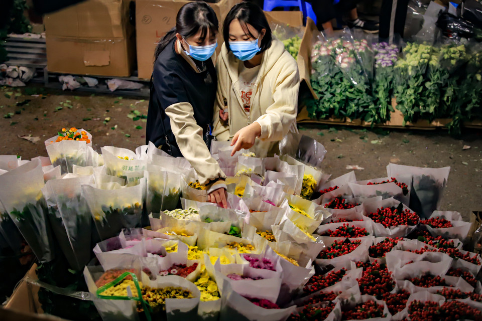 Nhiều người lựa mua hoa tại chợ đêm Quảng An vì vừa rẻ vừa tươi, hoa chuyển về đây vừa được thu hái từ các nhà vườn vẫn còn nguyên sương sớm. (Ảnh: Hoài Nam/Vietnam+)