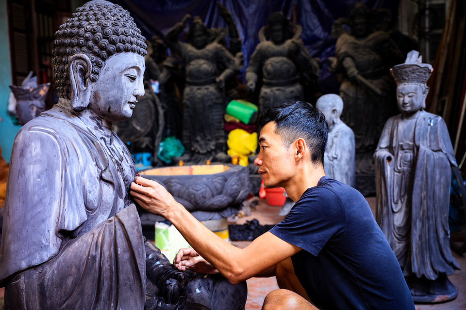 Đồng trang lứa với anh Đại trong làng Sơn Đồng, anh Phan Văn Anh là cháu trai nghệ nhân Phan Văn Ánh cũng đang tiếp tục công cuộc 'thổi hồn' vào gỗ của các bậc tiền nhân. (Ảnh: Hoài Nam/Vietnam+)