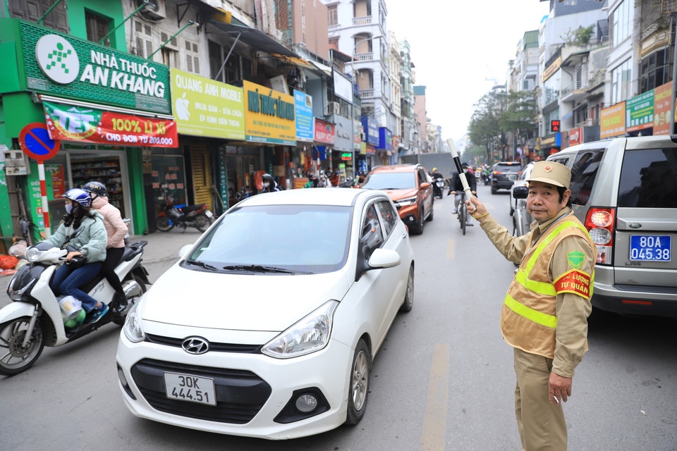 Tại các tuyến phố gần trung tâm Thủ đô, lượng phương tiện lưu thông lớn cả ngày, lực lượng tự quản tham gia điều tiết giao thông đảm bảo cho giao thông không bị ùn cục bộ. (Ảnh: Hoài Nam/Vietnam+)