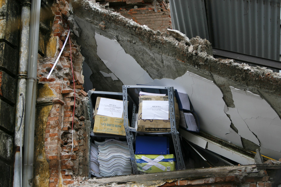 Giáp hai bên là lối đi liền kề của các hộ dân. Ngôi nhà sập theo phương thẳng đứng nên gạch đá tràn xuống làm bị thương một số người và tài sản.