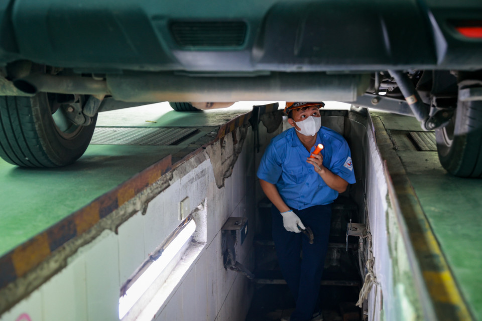 Kiểm định viên kiểm tra các bộ phận dưới gầm xe. (Ảnh: Hoài Nam/Vietnam+)