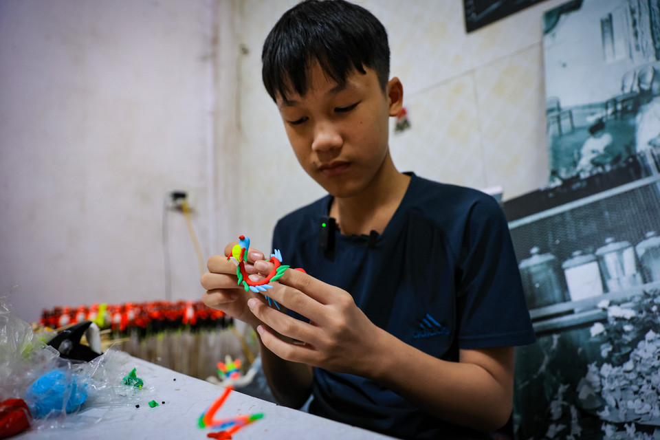 Đôi bàn tay khéo léo, tỉ mỉ tự sáng tạo những con tò he theo phong cách riêng của mình. (Ảnh: Hoài Nam/Vietnam+)