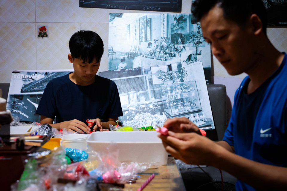 Sau hơn 20 năm gắn bó với bột màu, có nhiều học viên đã theo học và trở thành thợ lành nghề, nhưng có lẽ niềm vui lớn của anh là cậu con trai lớp 8 cũng đang say đắm với những con tò he. (Ảnh: Hoài Nam/Vietnam+)