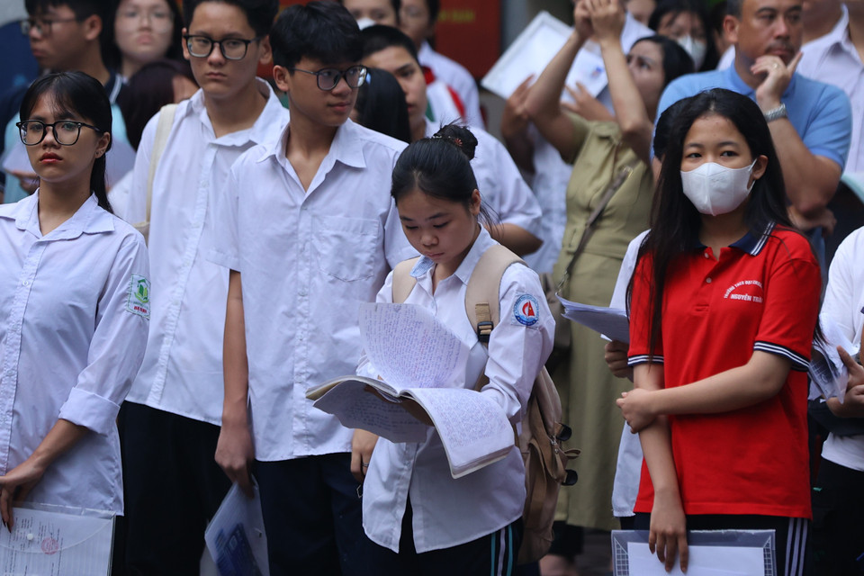 Một số thí sinh tranh thủ ôn lại các bài văn trước khi vào phòng thi. (Ảnh: PV/Vietnam+)