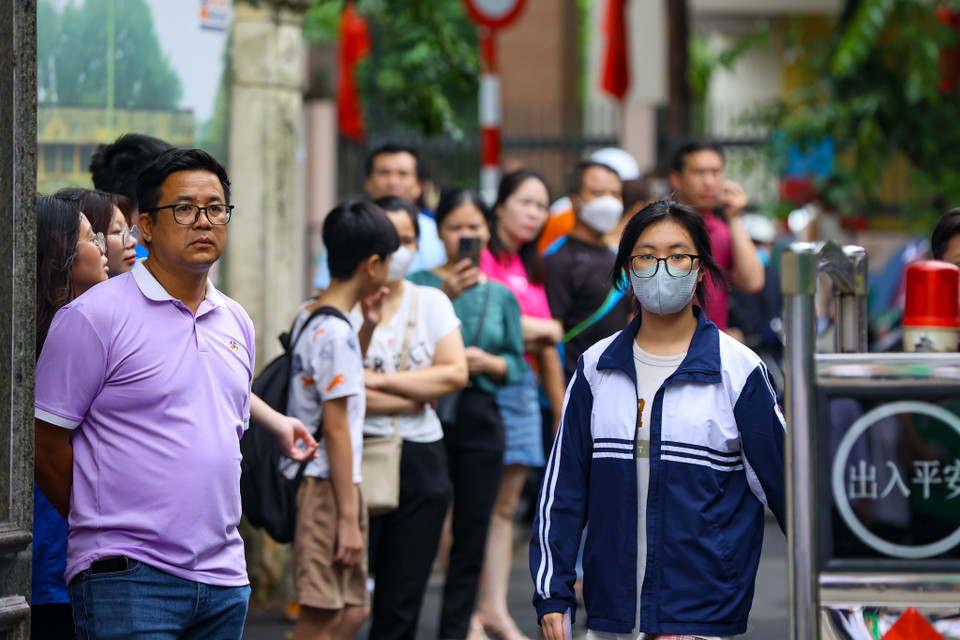 Phụ huynh dõi theo sỹ tử bước vào phòng thi với tâm trạng hồi hộp và lo lắng. (Ảnh: PV/Vietnam+)