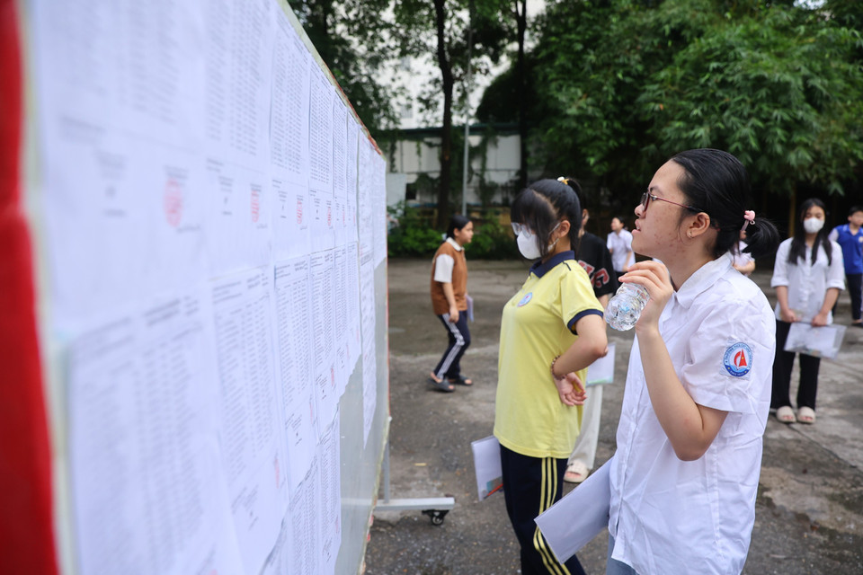 Các thí sinh xem sơ đồ phòng thi. (Ảnh: PV/Vietnam+)