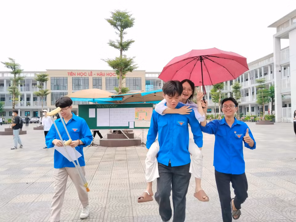 Các tình nguyện viên hỗ trợ thí sinh tại các điểm thi, vừa cổ vũ tinh thần cho sỹ tử tự tin trước giờ thi. (Ảnh: PV/Vietnam+)
