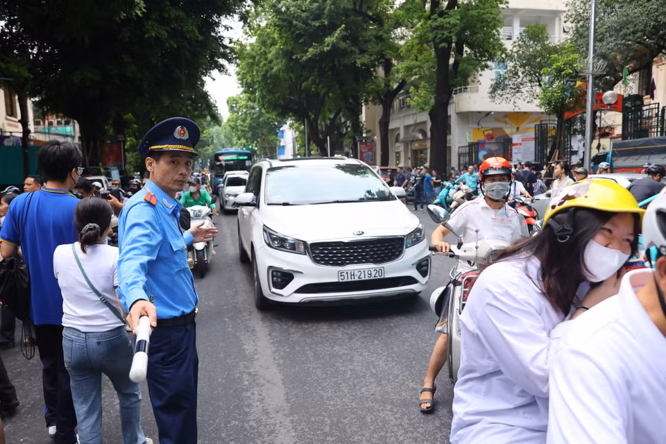 Bên cạnh những bậc làm cha mẹ, đồng hành cùng các sỹ tử ‘vượt vũ môn’ không thể thiếu lực lượng chức năng đảm bảo cho kỳ thi được diễn ra an toàn và thuận tiện nhất. (Ảnh: PV/Vietnam+)