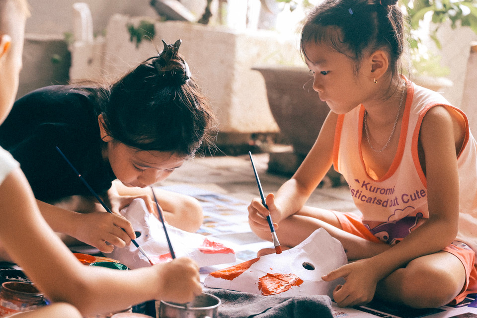 Những đứa trẻ trong xóm mê mẩn bên những chiếc cọ màu cùng mặt nạ sau giờ học trên trường. (Ảnh: Hoài Nam/Vietnam+)