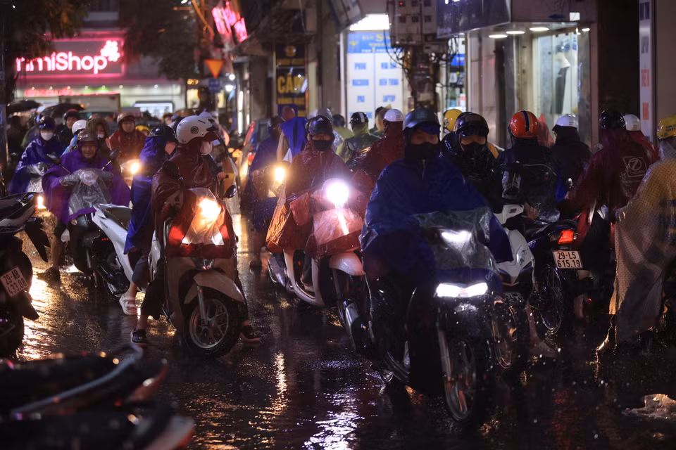 Nhiều phương tiện phải dừng lại không dám đi qua chỗ ngập vì sợ xe chết máy. (Ảnh: Hoài Nam/Vietnam+)