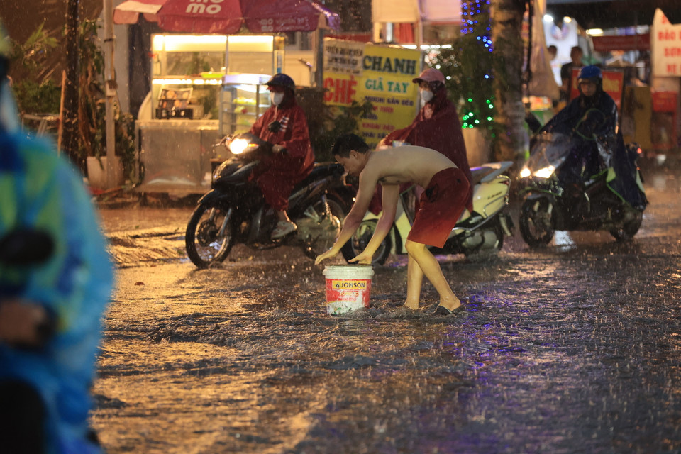 Người dân vớt rác tại các khu vực cống để tránh tình trạng ngập cục bộ. (Ảnh: Hoài Nam/Vietnam+)