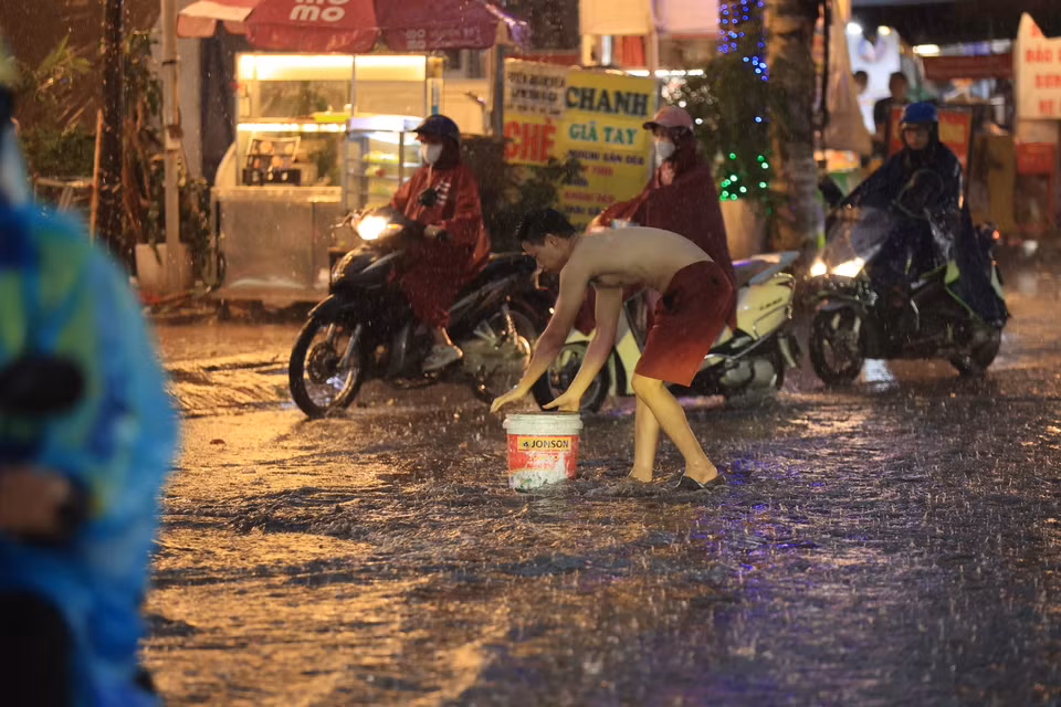 Người dân vớt rác tại các khu vực cống để tránh tình trạng ngập cục bộ. (Ảnh: Hoài Nam/Vietnam+)