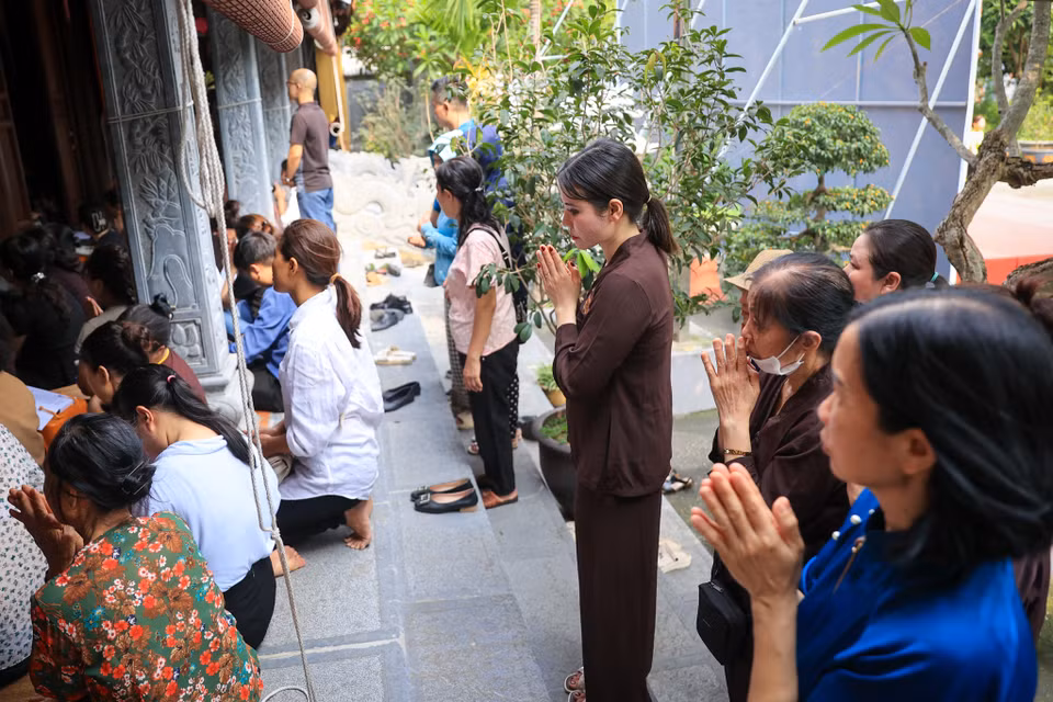 Nhiều người đứng vái vọng, thành tâm niệm Phật phía bên ngoài chính điện chùa Trung Kính Hạ. (Ảnh: PV/Vietnam+)
