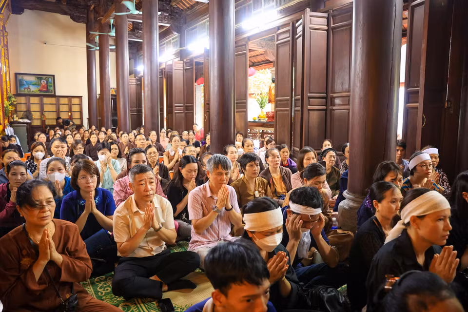 Thân nhân gia đình các nạn nhân cùng nhân dân có mặt tại buổi lễ thành tâm niệm Phật mong cho những người ra đi được siêu sinh tịnh độ. (Ảnh: PV/Vietnam+)