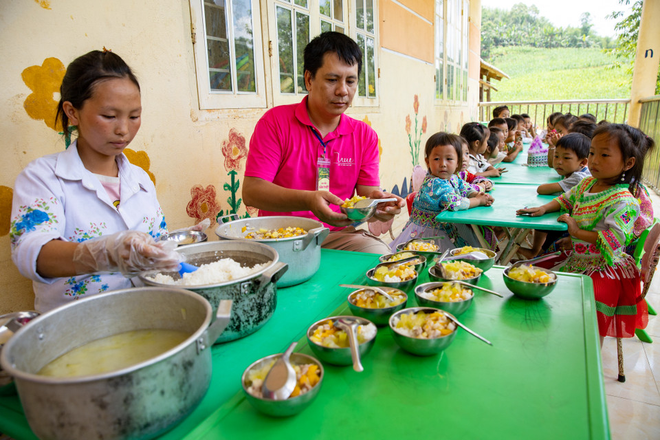Tại điểm trường, các tình nguyện viên trong chuyến đi “Mùa nắng Pác Miầu” thuộc hoạt động của dự án “Cùng em khôn lớn” cũng cùng tham gia hỗ trợ chuẩn bị bữa ăn bán trú cho các em học sinh. (Ảnh: PV/Vietnam+)