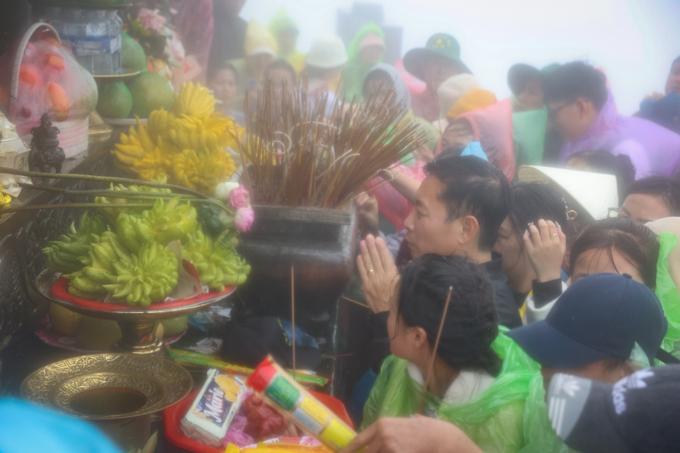 Người dân chen chân nhau dưới trời mưa cầu một năm mưa thuận gió hòa, sức khỏe và bình an cho gia đình. (Ảnh: Hoài Nam/Vietnam+)