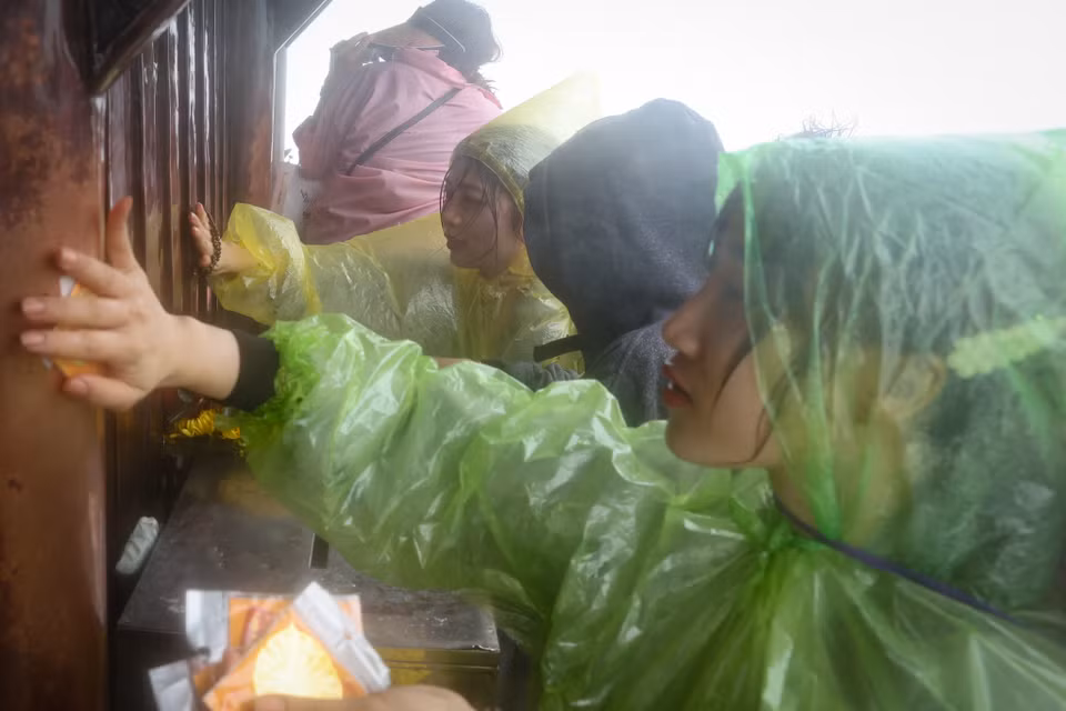 Lần đầu tiên lên đỉnh Yên Tử, chị Phạm Kim Cúc (Thanh Hóa) chia sẻ: "Mặc dù quãng đường leo những bậc dốc kèm mưa lớn nhưng lên được đến đây và dâng lễ nên cảm thấy rất hoan hỉ trong người." (Ảnh: Hoài Nam/Vietnam+)