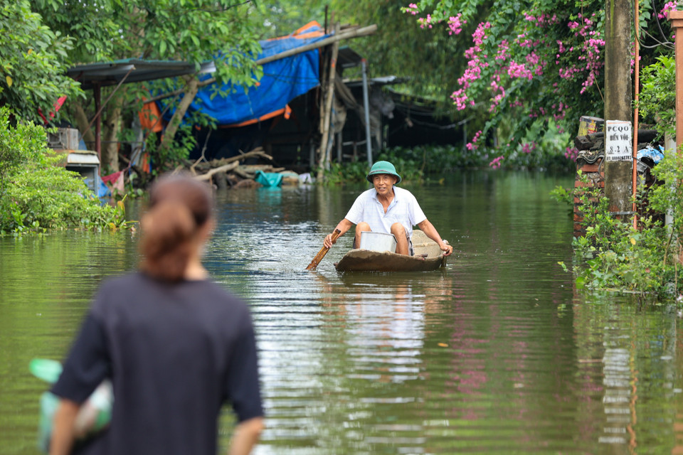 Người dân phải di chuyển bằng thuyền qua những nơi ngập sâu. (Ảnh: Hoài Nam/Vietnam+)