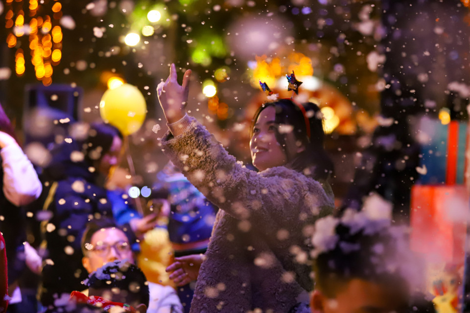 Đây là lần đầu tiên người dân Thủ đô được thưởng thức không gian mưa tuyết trên phố đi bộ. Không chỉ trẻ em mà người lớn cũng rất thích thú và hào hứng với tuyết giả tại đây. (Ảnh: Hoài Nam/Vietnam+)