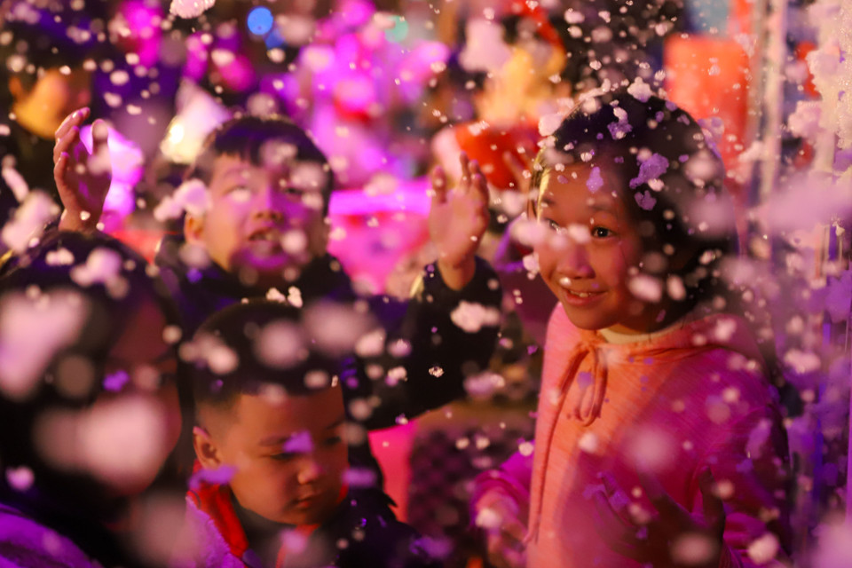 Tại phố đi bộ Trần Nhân Tông (Hai Bà Trưng, Hà Nội) tối nay, người dân đặc biệt là các em nhỏ được "ngắm tuyết rơi" trong đêm Noel. (Ảnh: Hoài Nam/Vietnam+)s