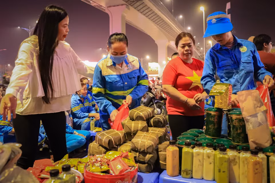 Chị Hương- thành viên hội thiện nguyện nói: ‘Có những đêm tôi mở cửa ra thấy cô lao công vẫn đang đưa từng nhịp chổi dưới trời Đông mưa phùn nhìn thương lắm, hôm nay được nhìn thấy nụ cười của các cô, chú lao công tôi thấy như chính niềm vui của mình.’ (Ảnh: Hoài Nam/Vietnam+)