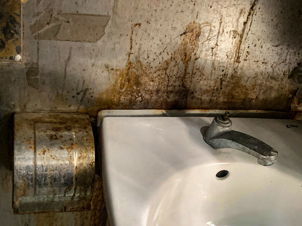 Vòi nước tại bồn rửa không còn sử dụng được, các hạng mục bằng kim loại đã hoen gỉ. (Ảnh: Hoài Nam/Vietnam+)