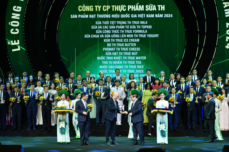 Thủ tướng Chính phủ Phạm Minh Chính và Bộ trưởng Công thương Nguyễn Hồng Diên trao biểu trưng và hoa cho đại diện các doanh nghiệp có sản phẩm đạt Thương hiệu Quốc gia Việt Nam năm 2024. (Ảnh: Hoài Nam/Vietnam+)