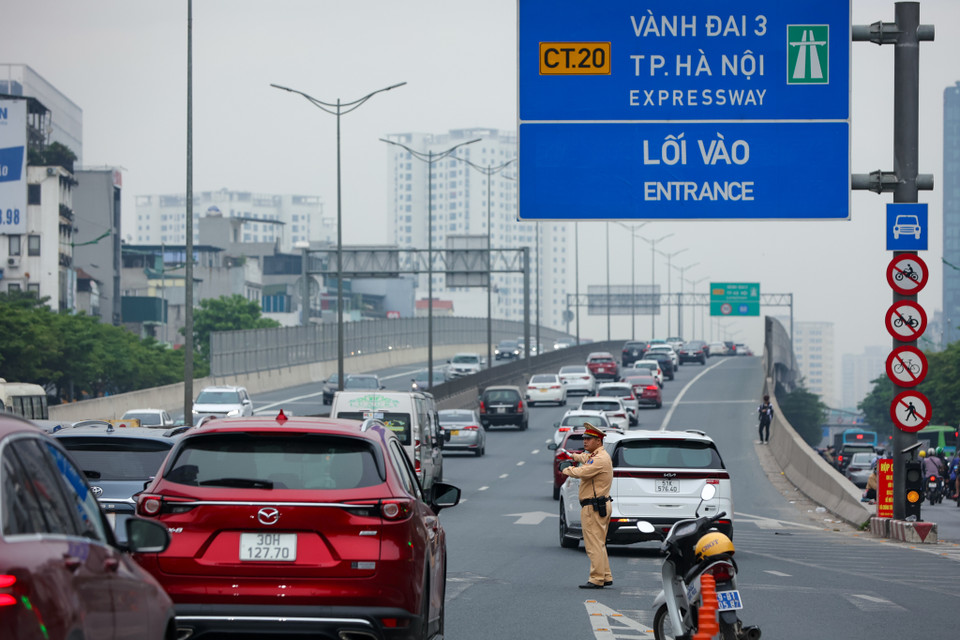 Lực lượng chức năng điều tiết, hướng dẫn người dân di chuyển. (Ảnh: Tuấn Anh/Vietnam+)