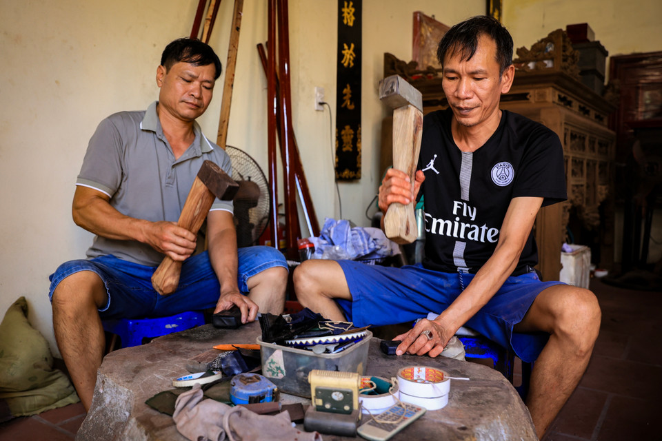 Những nhịp búa đều đều từ bàn tay chắc nịch nhưng hết sức tỉ mỉ của người Kiêu Kỵ có thể đập một chỉ vàng dàn mỏng thành tấm lá vàng có diện tích hơn 1m2. Muốn có một quỳ vàng, người thợ phải đập khoảng một giờ liên tục. (Ảnh: Hoài Nam/Vietnam+)