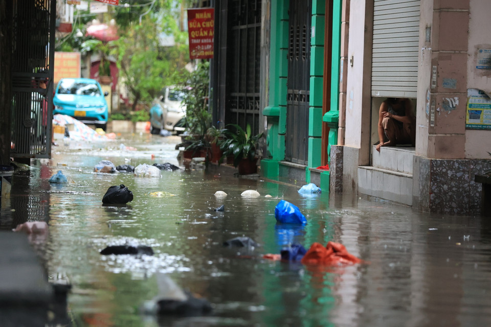 Cách đó không xa, cuối ngõ 149 Triều Khúc cũng ghi nhận nước ngập sâu với nhiều rác thải sinh hoạt nổi lềnh bềnh. (Ảnh: Hoài Nam/Vietnam+)