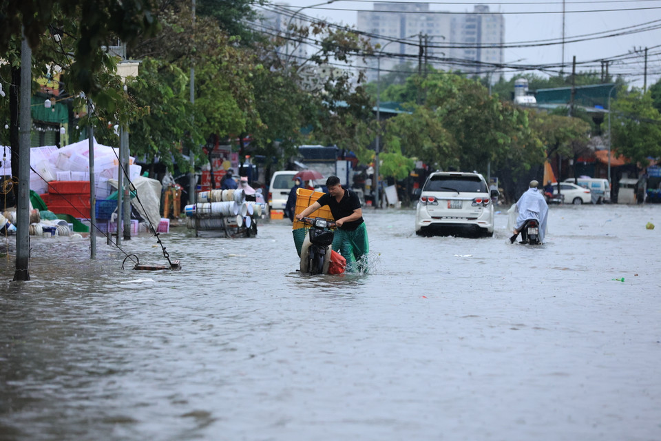 Đường Tân Triều mới (Thanh Trì, Hà Nội) mênh mông biển nước, phương tiện di chuyển khó khăn, một số khu vực ngập sâu khiến xe chết máy. (Ảnh: Hoài Nam/Vietnam+)
