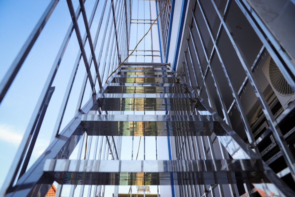 Thợ thi công cho biết cầu thang thoát hiểm phải được tính toán chịu lực và hàn gắn chắc chắn, đảm bảo có thể phát huy tác dụng khi có sự cố. (Ảnh: Hoài Nam/Vietnam+)