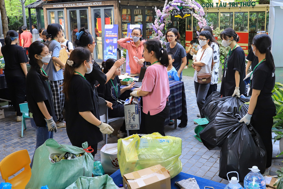 Các bạn tình nguyện viên, cộng tác viên cũng như thành viên của tổ chức hỗ trợ người tham gia hoạt động đổi rác lấy cây. (Ảnh: Hoài Nam/Vietnam+)