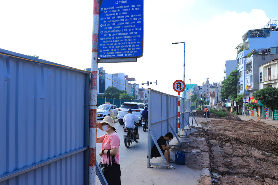 Người dân đứng chờ xe bus ngay cạnh công trường đang ngổn ngang, tiềm ẩn nhiều nguy cơ tai nạn. (Ảnh: Hoài Nam/Vietnam+)