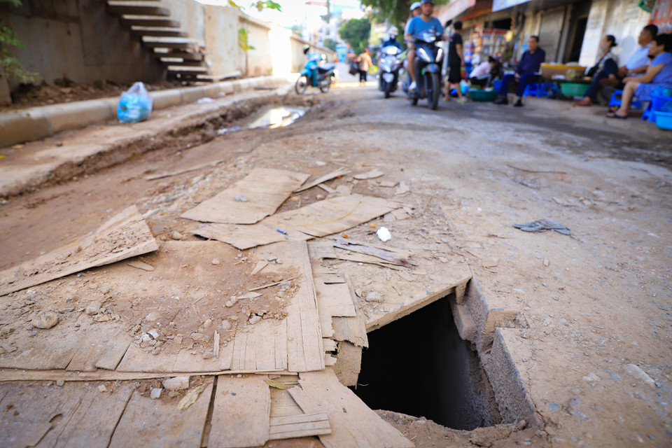 Hố ga được che phủ bởi tấm gỗ mỏng manh, rất nguy hiểm cho các phương tiện di chuyển qua khu vực này, nhất là vào những ngày trời mưa tầm nhìn bị hạn chế. (Ảnh: Hoài Nam/Vietnam+)