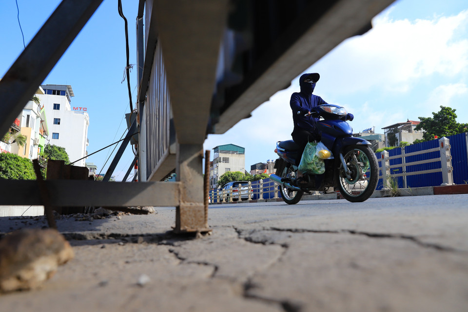 Mặt đường một số nơi bị sụt lún, nứt nẻ do việc phá đê cũ bằng đất thay thế bằng bê tông cốt thép chưa hoàn thành. (Ảnh: Hoài Nam/Vietnam+)