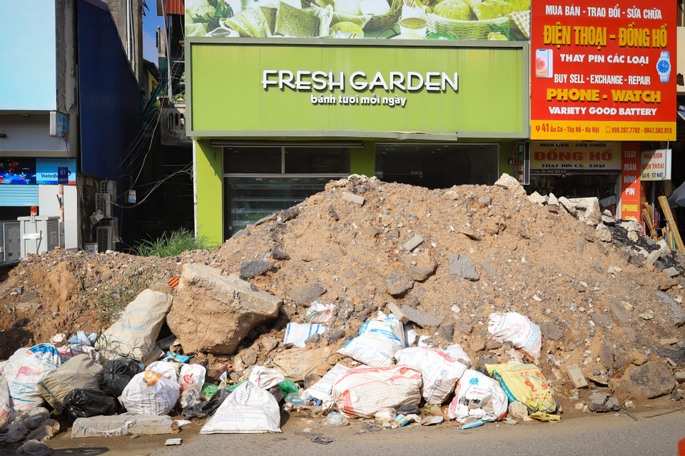 Có đoạn phế liệu từ công trình che lấp gần hết mặt tiền một cửa hàng ảnh hưởng đến việc kinh doanh buôn bán của người dân. (Ảnh: Hoài Nam/Vietnam+)