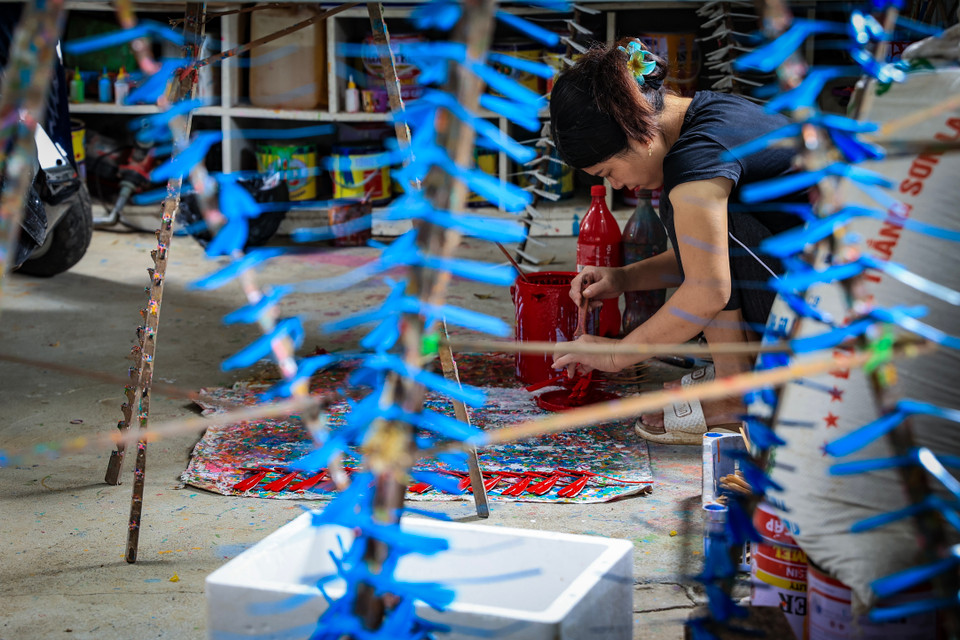 Người thợ cần khéo léo để trải đều sơn ra, nếu không sẽ bị loang màu, chất liệu sơn ta sẽ giúp cho sản phẩm vừa bền, vừa đẹp. (Ảnh: Hoài Nam/Vietnam+)