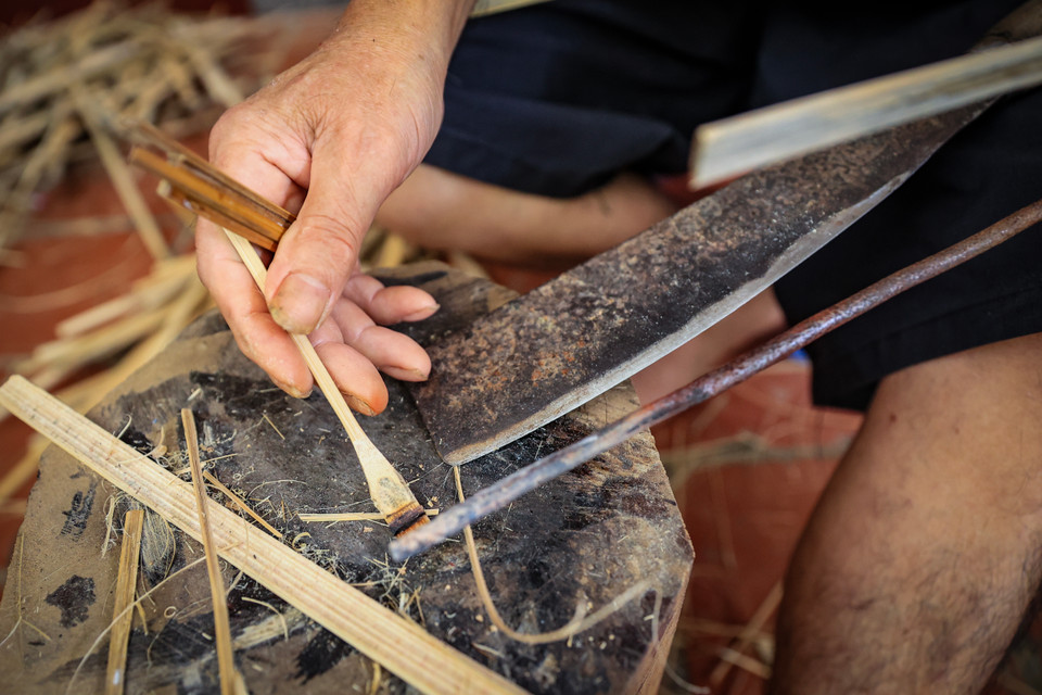 Người thợ sẽ dùng một thanh sắt nung nóng để uốn phần đầu chuồn chuồn, tạo thăng bằng với cánh và đuôi giúp chuồn chuồn có thể đậu được. (Ảnh: Hoài Nam/Vietnam+)