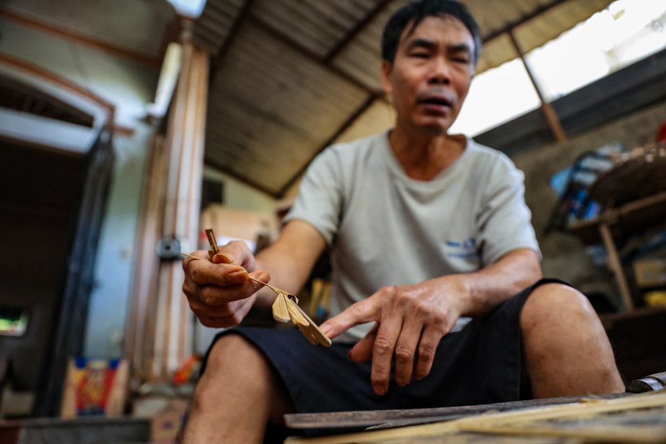 Ông Khẩn bảo làm chuồn chuồn tre cần phải tỉ mỉ từng ly, để cho sản phẩm làm ra vừa đẹp mắt nhưng phải cân đối để con chuồn chuồn 'đậu' được ở bất kể đâu. (Ảnh: Hoài Nam/Vietnam+)