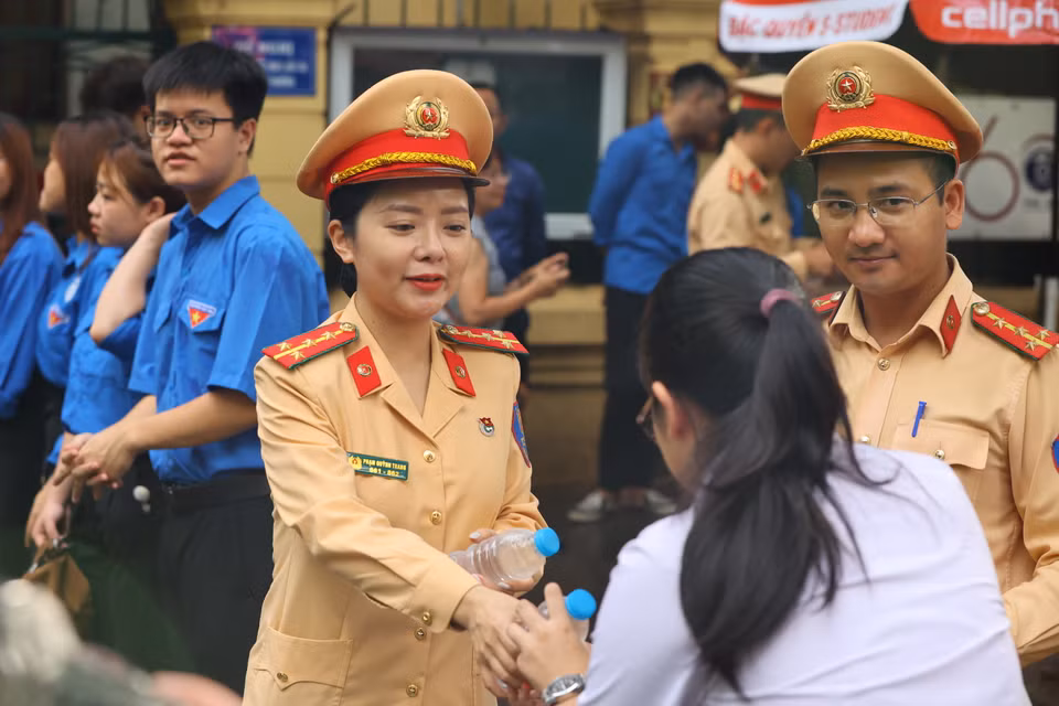 Lực lượng Cảnh sát giao thông công an thành phố Hà Nội tiếp nước, 'truyền lửa' cho thí sinh. (Ảnh: PV/Vietnam+)