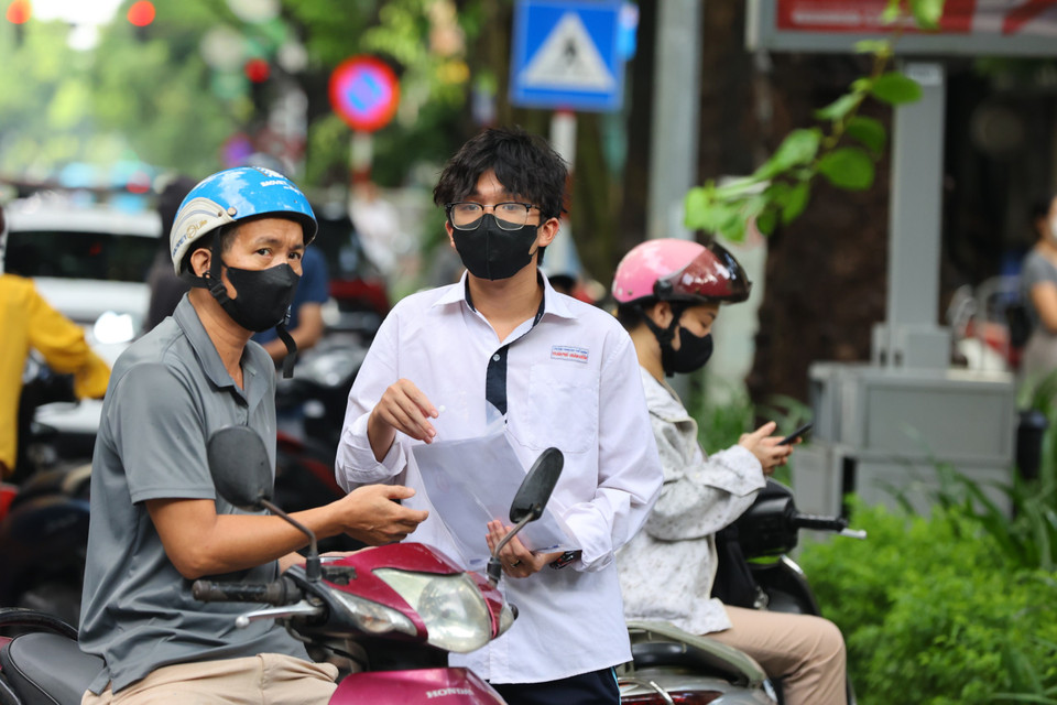 Phụ huynh đưa con đến điểm thi dặn dò và cổ vũ tinh thần cho con đạt được kết quả tốt nhất trong môn thi ‘mở màn.’ ﻿(Ảnh: PV/Vietnam+)