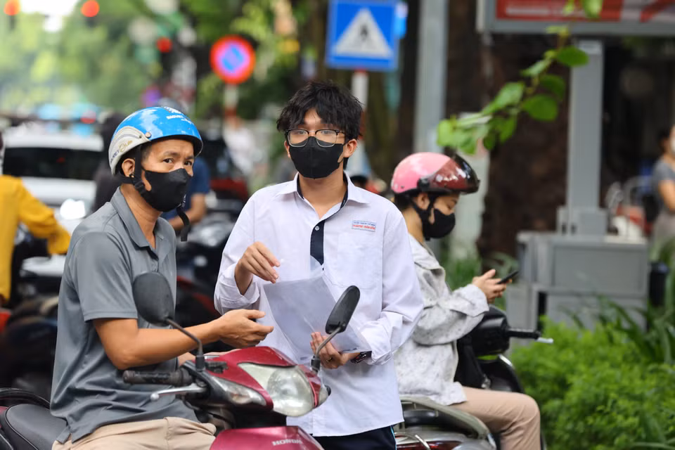 Phụ huynh đưa con đến điểm thi dặn dò và cổ vũ tinh thần cho con đạt được kết quả tốt nhất trong môn thi ‘mở màn.’ ﻿(Ảnh: PV/Vietnam+)